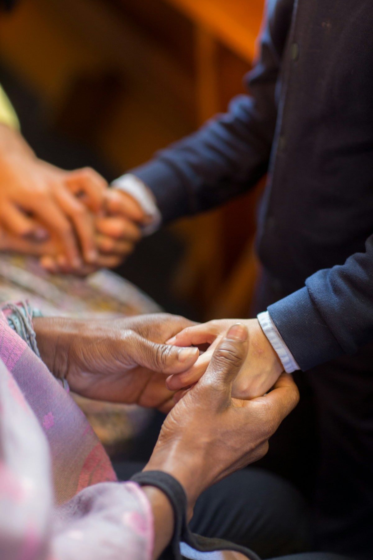 Hands clasped in a gesture of support while arranging care after a death.