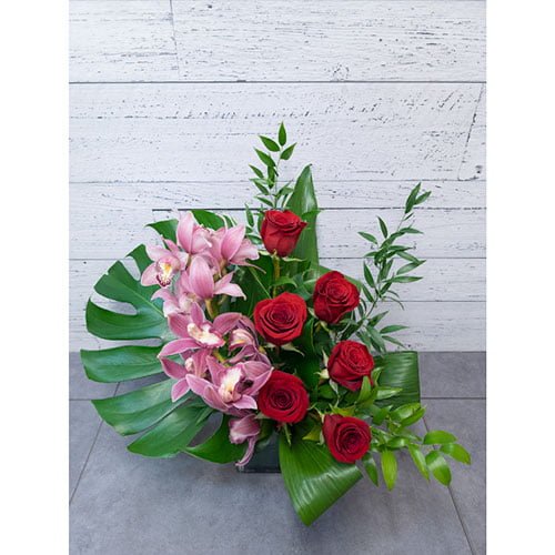 Arrangement of red roses and an orchid