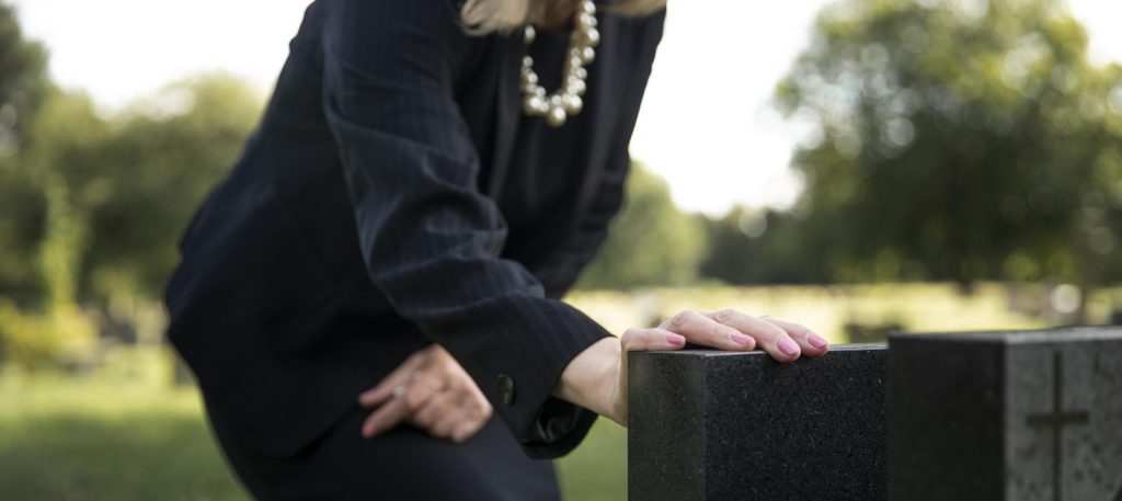 femme âgée visitant la tombe d'un être cher